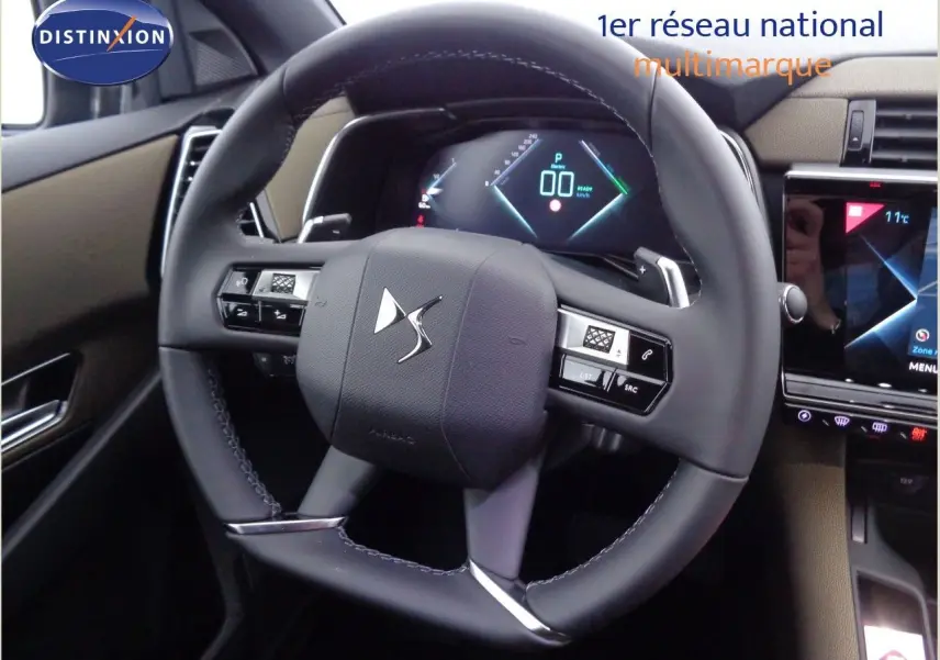 Gros plan sur le volant cuir noir et le tableau de bord numérique du DS7 Crossback E-TENSE 2021, intérieur beige et noir.
