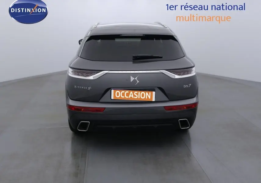 Vue arrière d'un DS7 Crossback gris platinium métal avec feux LED et double sortie d'échappement carrée.