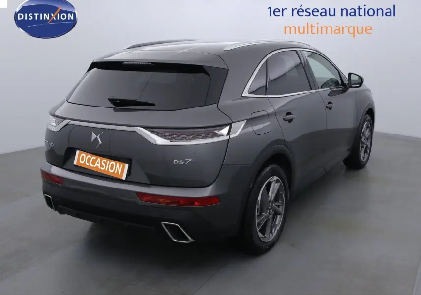 Vue 3/4 arrière droite d'un DS7 Crossback gris platinium métal avec feux LED et double sortie d'échappement rectangulaire.