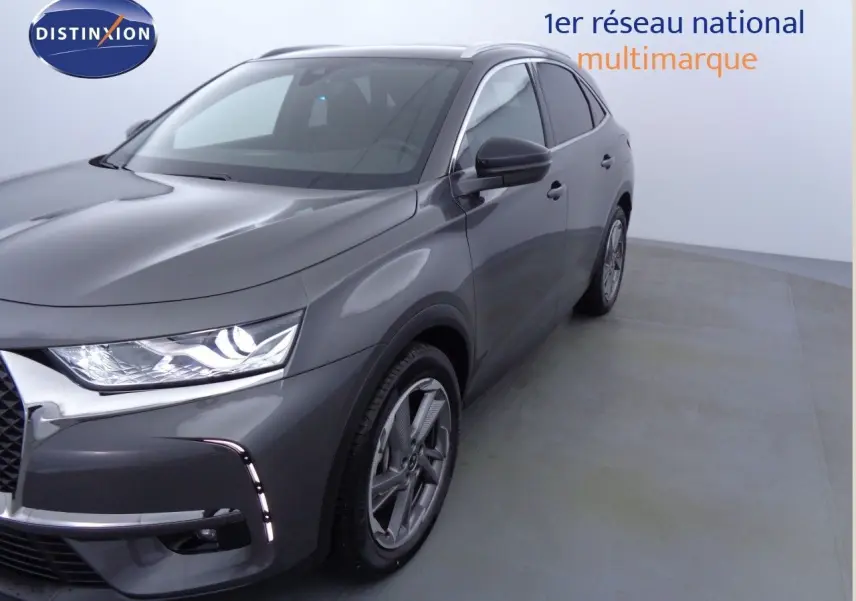 DS7 Crossback E-TENSE gris platinium métal en 3/4 avant droit, avec phares LED allumés et jantes alliage visibles.