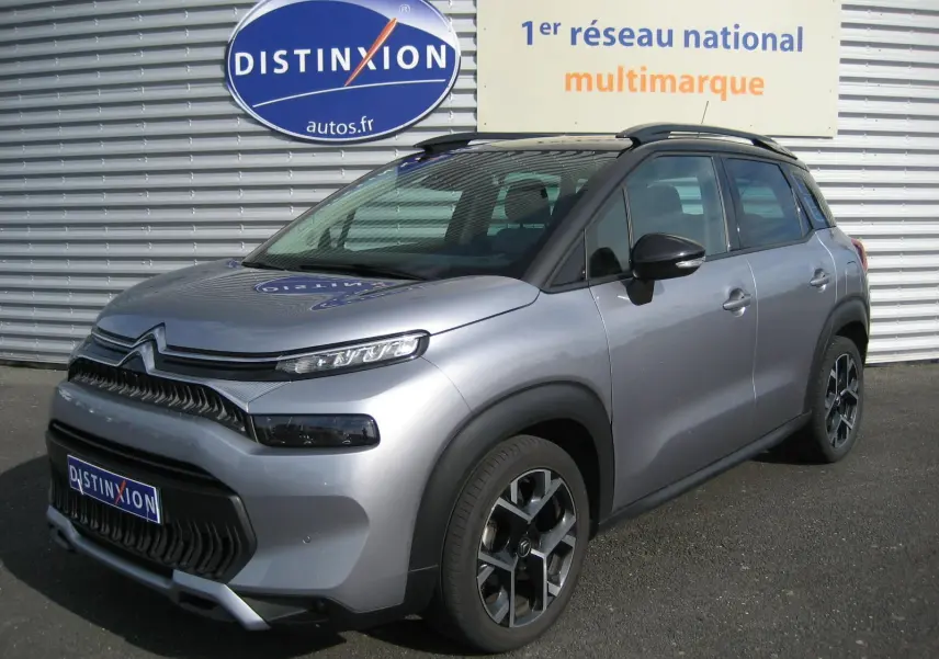 Citroën C3 Aircross gris vue 3/4 avant droit, avec toit noir et jantes alliage distinctives.