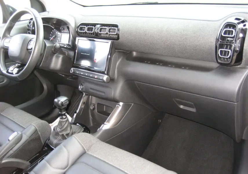 Vue intérieure côté passager du tableau de bord gris et noir du Citroën C3 Aircross II 2022 avec boîte manuelle.