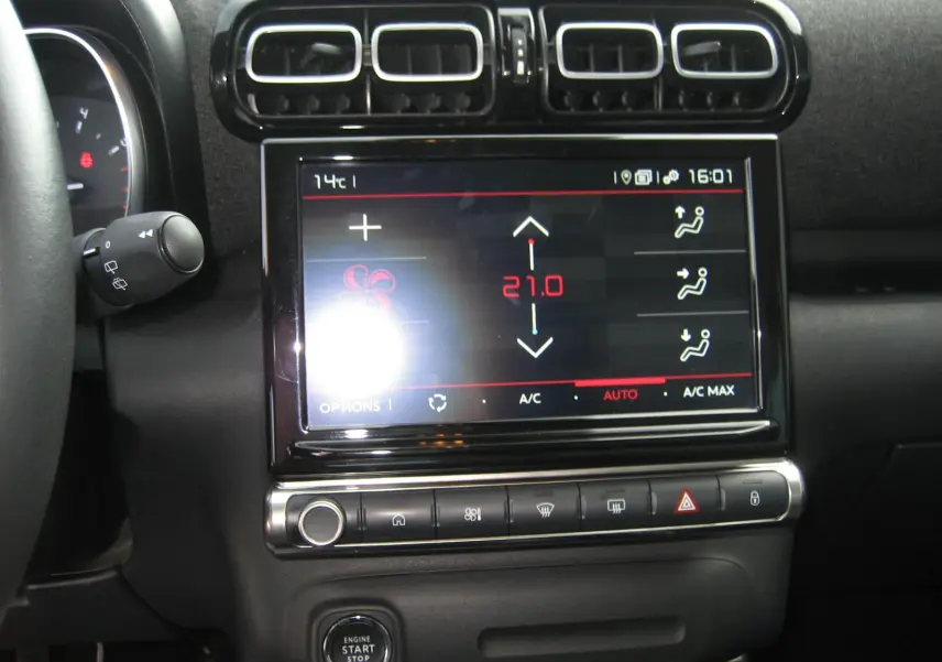Vue rapprochée du tableau de bord du Citroën C3 Aircross gris 2022, mettant en valeur l'écran tactile de climatisation.