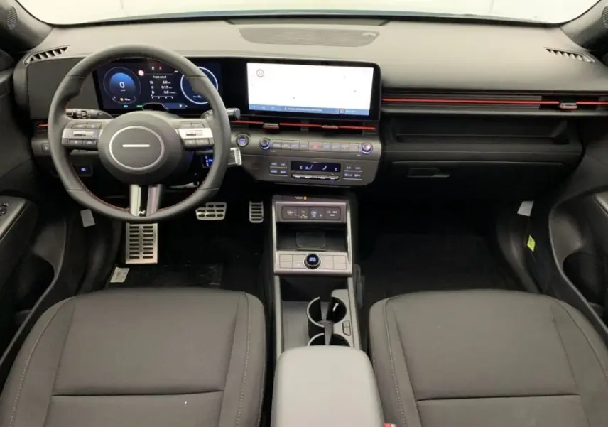 Vue intérieure frontale du tableau de bord du Hyundai Kona Hybrid 2025, avec écran tactile large et volant multifonction noir.