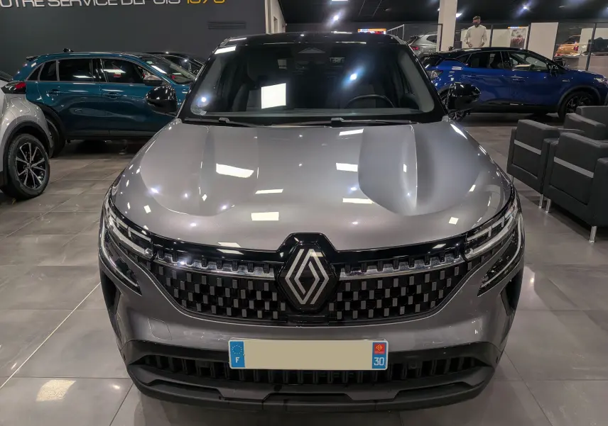 Vue frontale du Renault Austral gris schiste avec toit noir, mettant en valeur sa calandre moderne et son logo central.