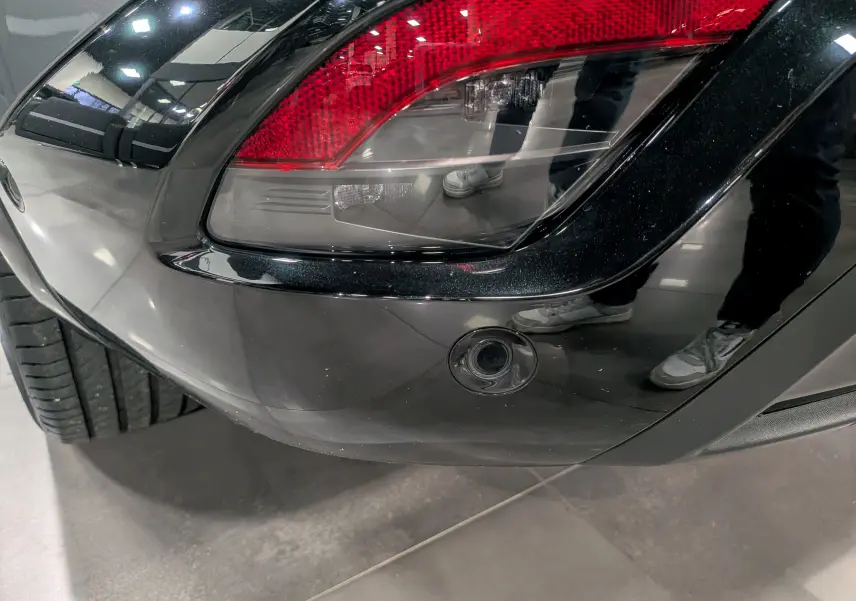 Gros plan sur le feu arrière droit gris schiste du Renault Austral 2024 avec toit noir et capteur de recul intégré.