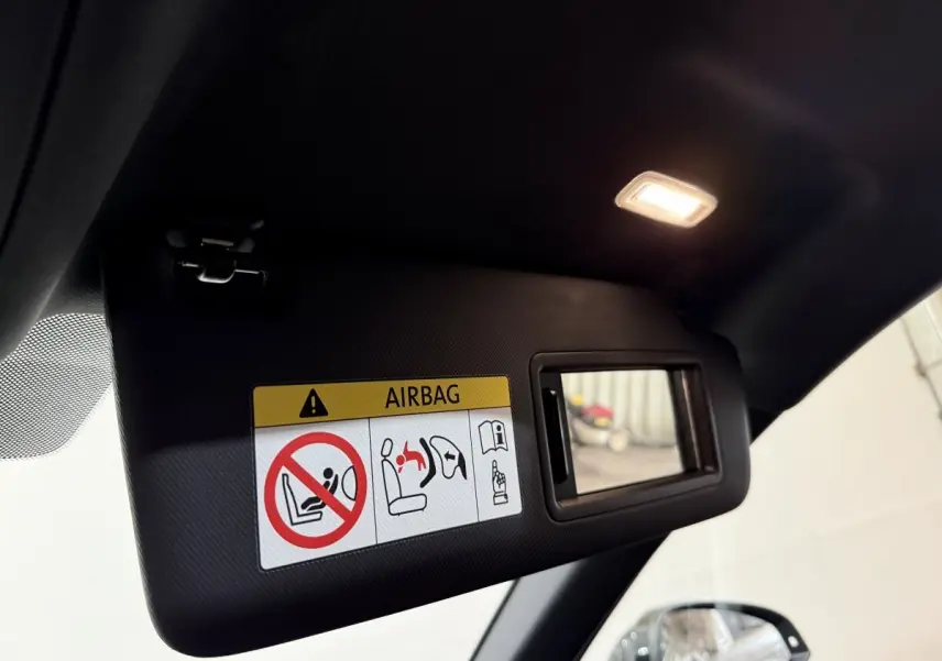 Détail du pare-soleil côté conducteur avec miroir éclairé et avertissement airbag dans un Audi A4 gris foncé 2022.