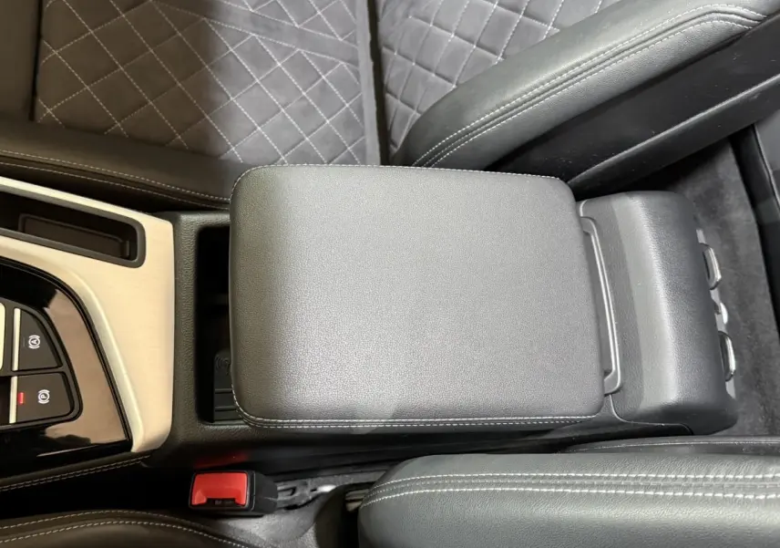 Vue rapprochée de l'accoudoir central en cuir gris foncé avec surpiqûres blanches dans l'Audi A4 35 TFSI S Edition 2022.