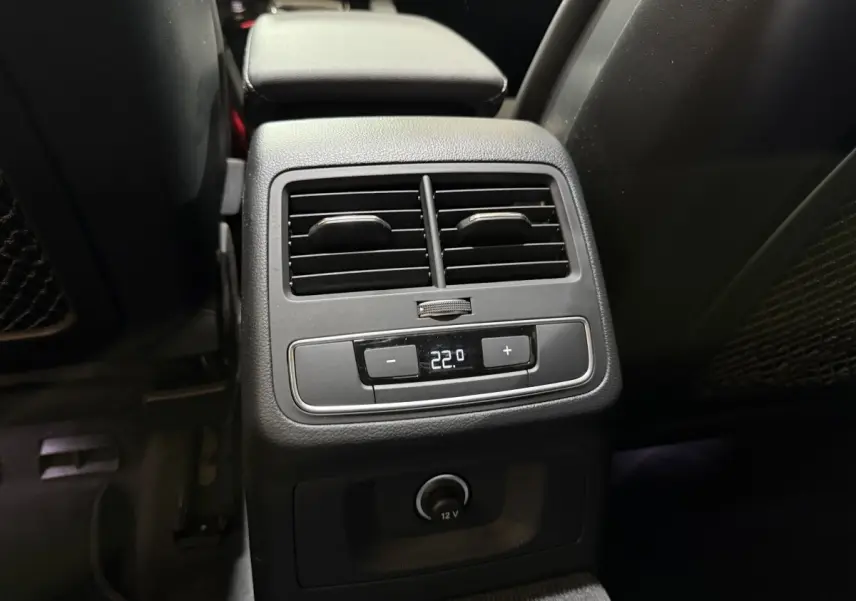 Vue rapprochée de la console arrière noire de l'Audi A4 35 TFSI 2022 avec commandes climatisation et prise 12V.