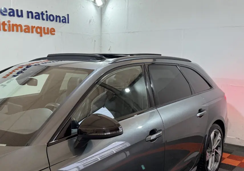 Vue côté gauche d'un Audi A4 35 TFSI S Edition gris foncé avec toit ouvrant et jantes alliage visibles.