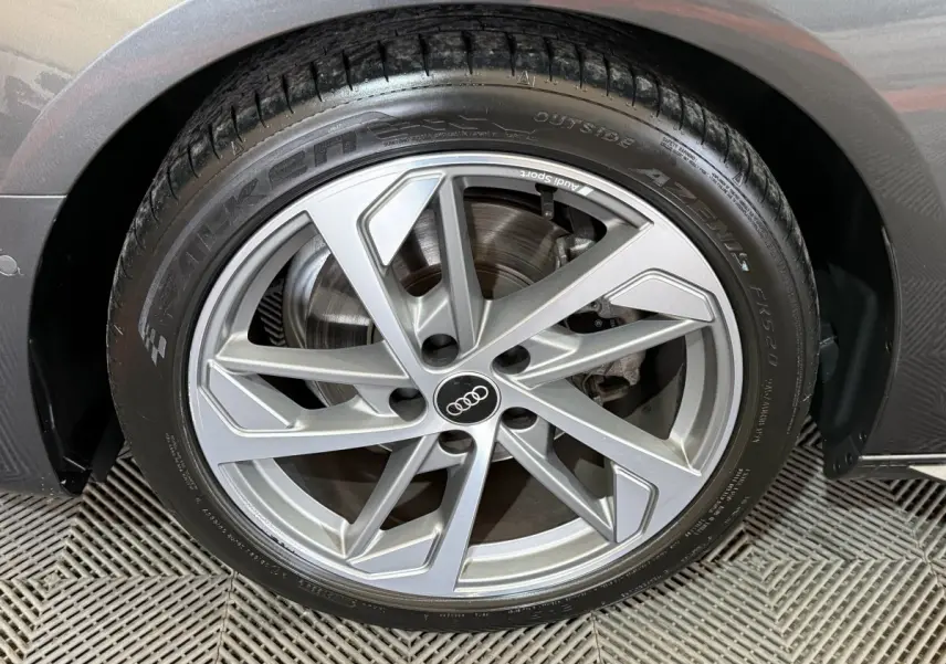Gros plan sur la roue avant droite gris foncé d’une Audi A4 35 TFSI S Edition avec jante en alliage moderne.