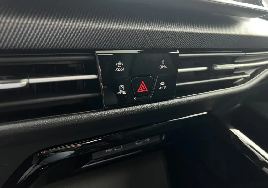 Détail du tableau de bord noir de la Volkswagen Golf VIII R-Line montrant les commandes d'assistance et climatisation.