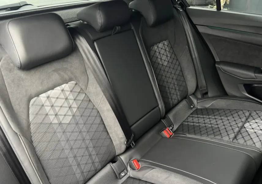 Vue intérieure des sièges arrière en cuir et tissu gris à motifs de la Volkswagen Golf VIII R-Line noire.