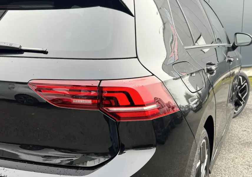 Vue arrière côté droit d'une Volkswagen Golf VIII noire avec feux arrière LED et jantes alliage 18 pouces.
