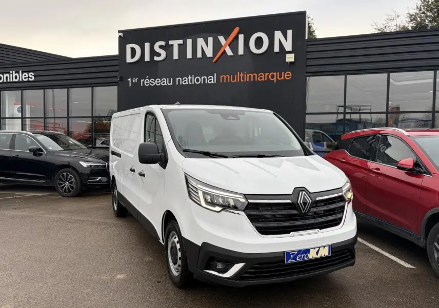Renault Trafic Fourgon blanc glacier en 3/4 avant droit, avec projecteurs Full LED et calandre noire distinctive.