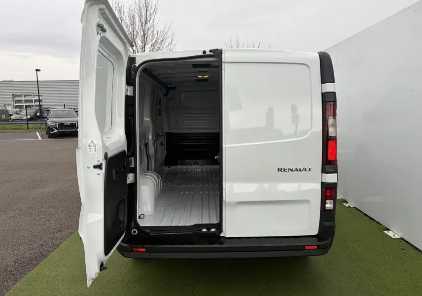 Vue arrière du Renault Trafic Fourgon blanc Glacier 2025 avec porte gauche ouverte montrant l'intérieur vide du coffre.