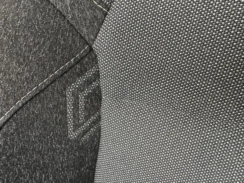Détail du tissu gris texturé et coutures apparentes sur le siège avant d’un Renault Captur 2025.