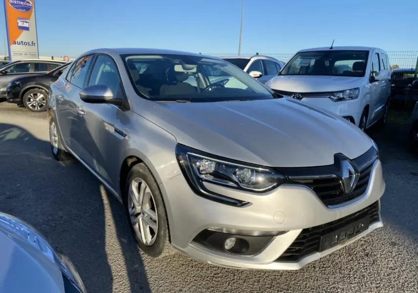 Renault Mégane gris platine vue 3/4 avant droit avec projecteurs antibrouillard et calandre noire.