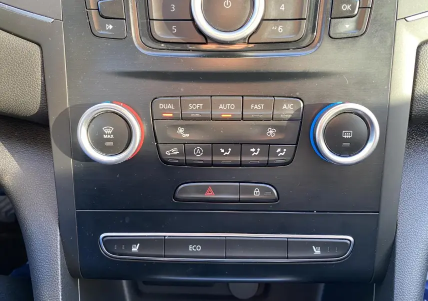 Vue rapprochée de la console centrale noire de la Renault Mégane 2017 avec commandes de climatisation et sièges chauffants.