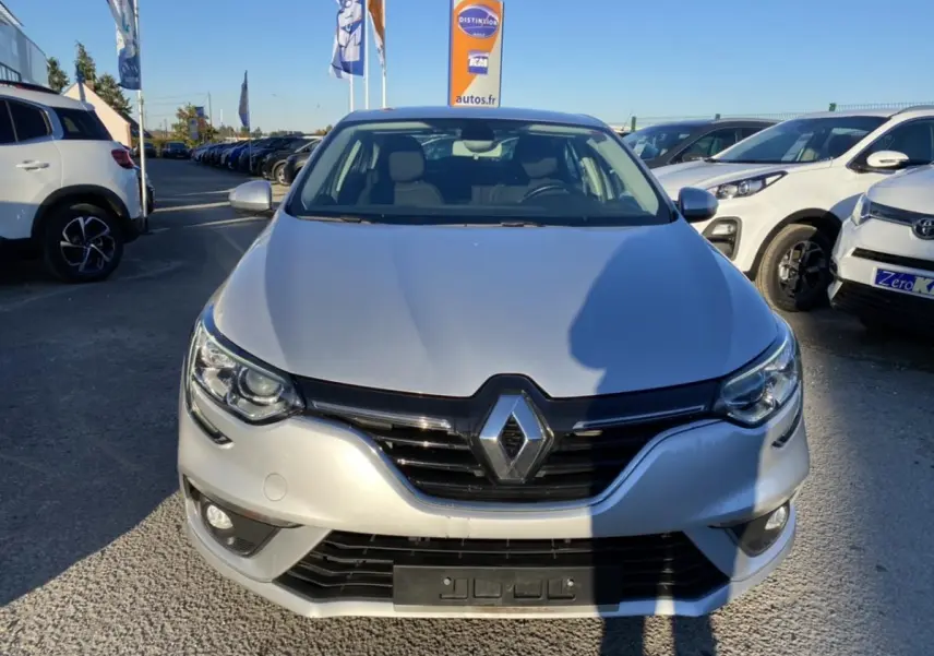 Vue avant d'une Renault Mégane Sedan gris platine 2017 avec projecteurs antibrouillard et calandre noire brillante.