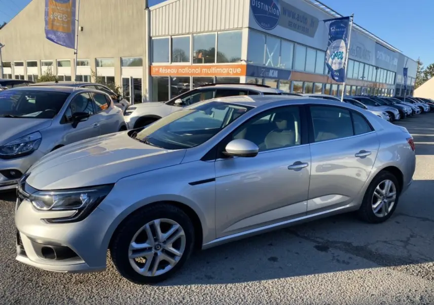 Renault Mégane Sedan gris platine vue de profil côté gauche, avec jantes alliage et projecteurs antibrouillard avant.