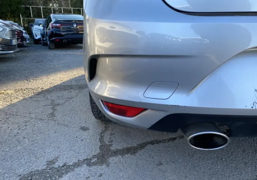 Détail du pare-chocs arrière droit gris platine de la Renault Mégane Sedan 2017 avec sortie d’échappement visible.