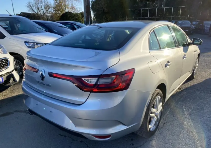 Renault Mégane Sedan gris platine vue 3/4 arrière droit, avec feux arrière allongés et jantes alliage.