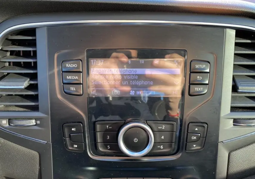 Vue rapprochée de la console centrale de la Renault Mégane 2017, écran tactile avec commandes radio et climatisation.