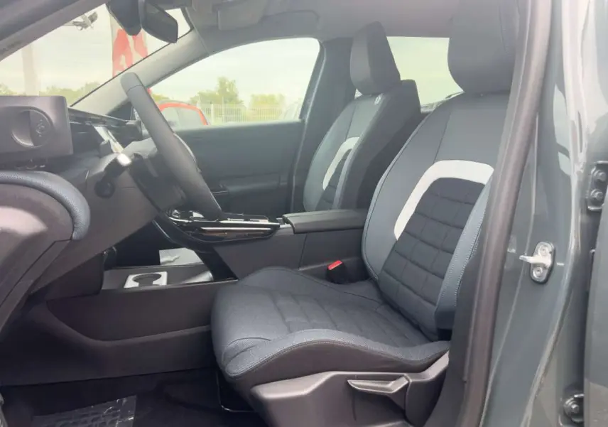 Vue intérieure côté conducteur du Citroën C5 Aircross Hybrid 145 Plus PK Drive 2026, sièges tissu gris avec surpiqûres blanches.