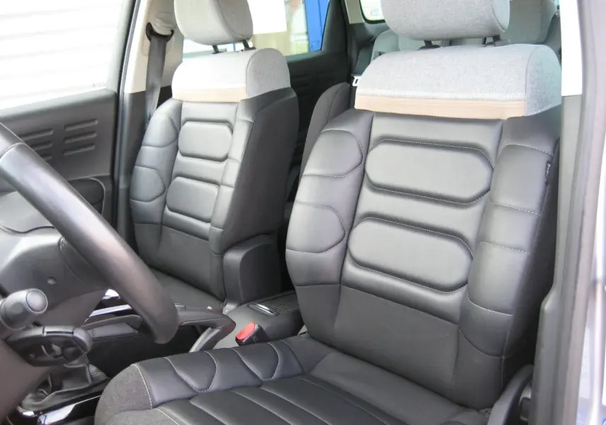 Intérieur du Citroën C3 Aircross gris platinium, vue rapprochée des sièges avant en cuir noir et tissu gris.
