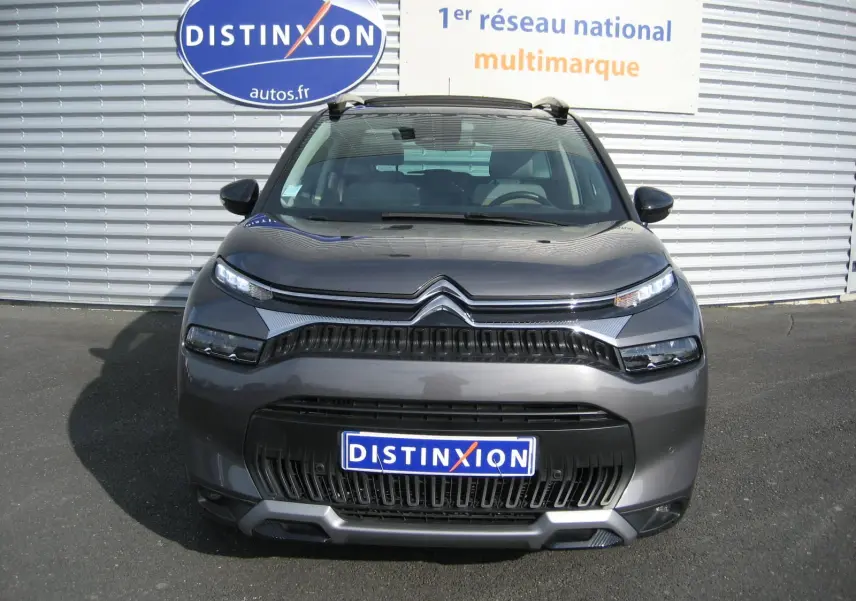 Vue frontale d'un Citroën C3 Aircross gris platinium avec calandre noire et phares LED fins.