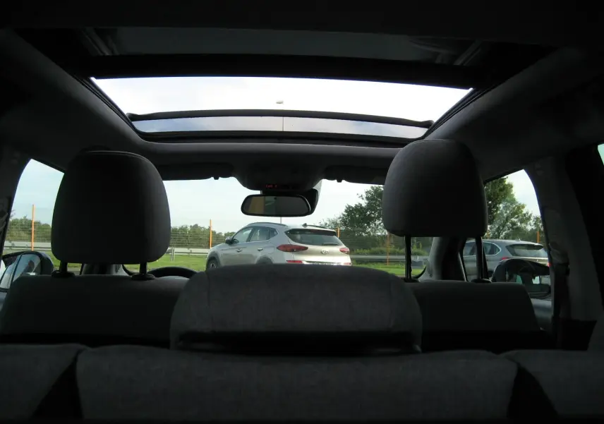 Vue intérieure arrière montrant le toit ouvrant panoramique et les appuie-têtes du Citroën C3 Aircross gris platinium.