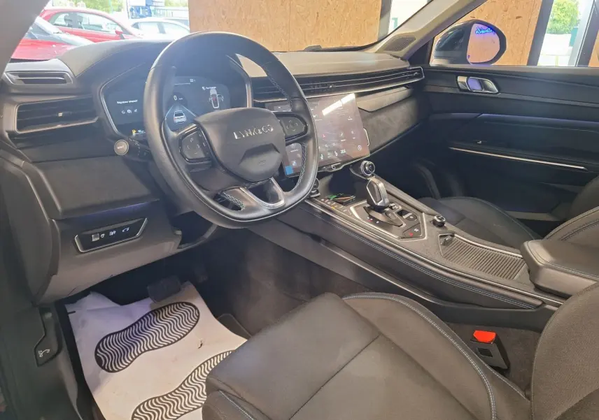 Vue intérieure côté conducteur du Lynk & Co 01 hybride rechargeable noir, avec tableau de bord numérique et console centrale moderne.