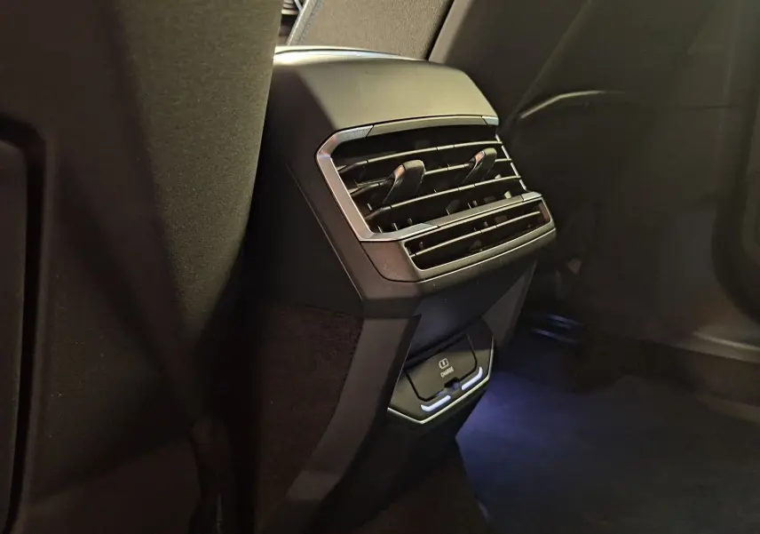 Gros plan sur la ventilation arrière et prise USB avec éclairage bleu à l'arrière d'un LYNK & CO 01 noir hybride rechargeable.