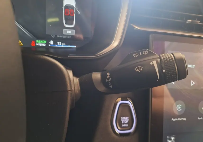 Gros plan sur la manette d'essuie-glace et le bouton start/stop dans l'habitacle du Lynk & Co 01 noir hybride rechargeable.