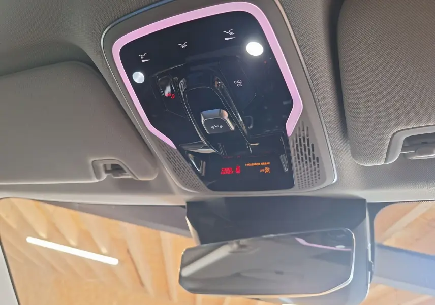 Vue du plafonnier intérieur du Lynk & Co 01 2023 avec éclairage d'ambiance violet et commandes tactiles noires.