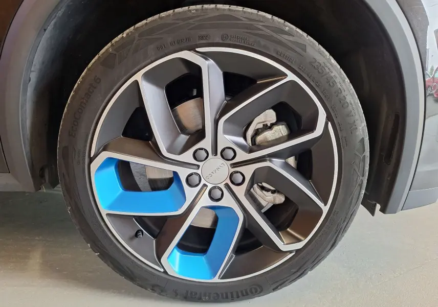 Gros plan sur la jante avant droite du Lynk & Co 01 noir, avec inserts bleus et pneu Continental EcoContact 6.