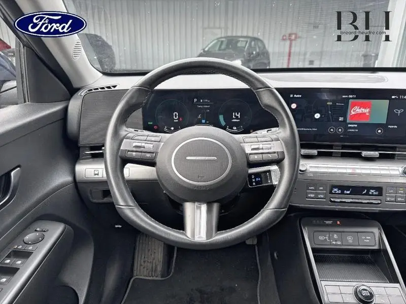 Vue intérieure centrée sur le volant cuir multifonction et l'écran tactile du Hyundai Kona Denim Blue 2023.