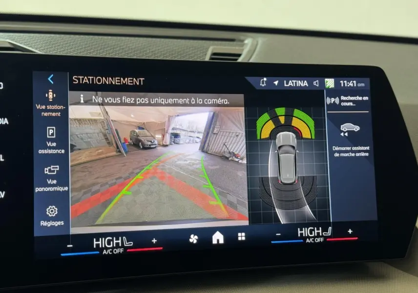 Écran tactile intérieur montrant l’aide au stationnement avec vue caméra arrière et capteurs du BMW X1 gris foncé 2024.