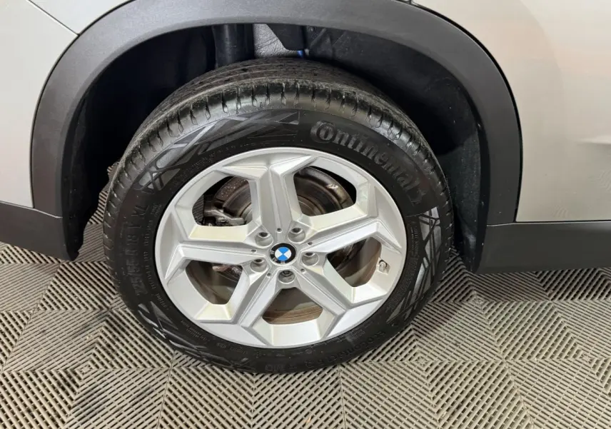 Gros plan sur la roue avant droite gris foncé d’un BMW X1 2024 avec jante alliage et pneu Continental.