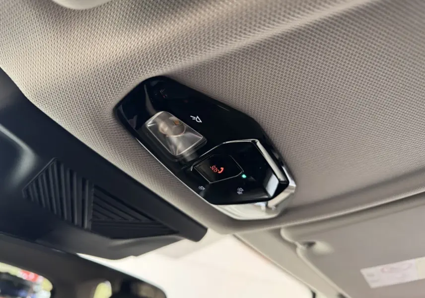 Vue intérieure en contre-plongée du plafonnier gris clair avec commandes d'éclairage et bouton SOS du BMW X1 2024.