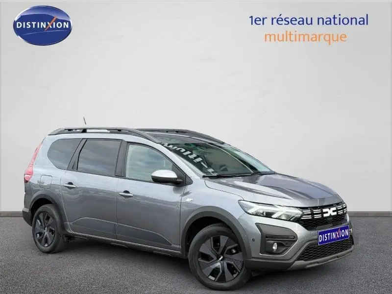 Vue 3/4 avant droit du Dacia Jogger gris schiste métallisé avec toit noir et jantes noires distinctives.