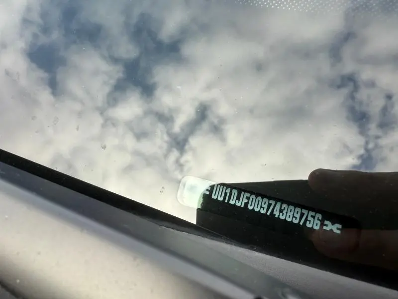 Image montrant le reflet du ciel sur le pare-brise d’un Dacia Jogger gris Schiste métallisé, vue rapprochée sans angle précis.