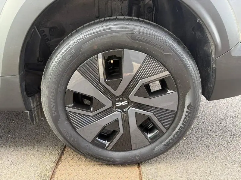 Gros plan sur la roue avant gauche du Dacia Jogger 2025 gris Schiste métallisé avec jante au design moderne noir et gris.