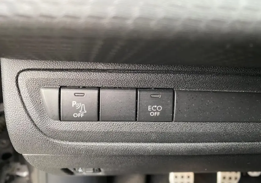 Gros plan sur les boutons de commande du tableau de bord du Peugeot 2008 GT Line 2017, avec fonction ECO et aide au stationnement désactivées.