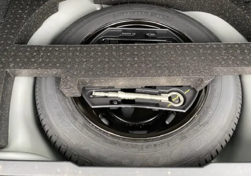 Gros plan sur la roue de secours tôle 15 pouces du coffre d'une Peugeot 2008 GT Line gris platinium de 2017.