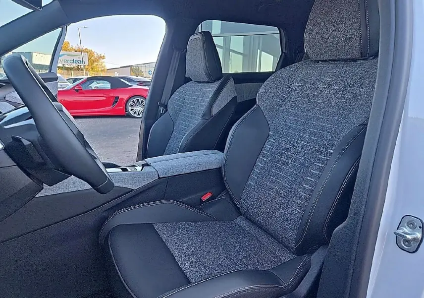 Vue intérieure côté conducteur du Peugeot 5008 Hybrid 145 allure e-dcs6 2025, sièges tissu gris et cuir noir.