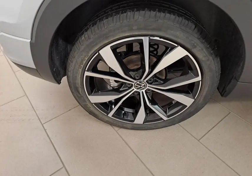 Gros plan sur la roue avant droite du Volkswagen T-Cross 2025 R-Line Edition en Reflet d'argent, jante alliage bicolore.