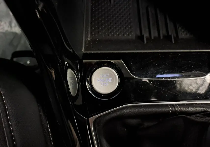 Bouton start/stop moteur en gros plan sur la console centrale noire brillante du Volkswagen T-Cross 2025 R-Line Edition.