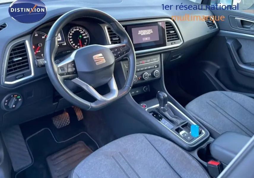 Vue intérieure avant droite du SEAT Ateca 2022 avec tableau de bord noir et sièges tissu gris.